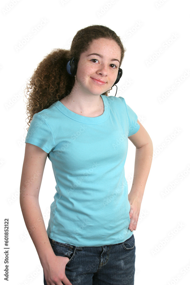 Obraz premium A smiling teen girl in a blank blue t-shirt and listening to headphones. Tee shirt ready for logo.