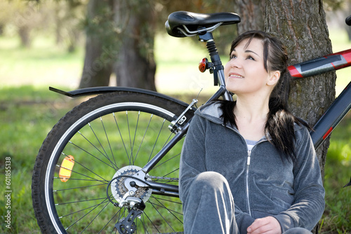 happy brunette woman relaxing in park with bike