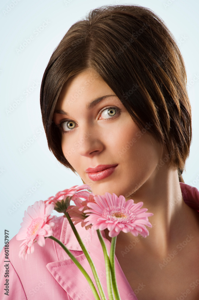nice shot of a cute young woman with pink flowers looking in camera nice shot of a cute young woman with pink flowers looking in camera