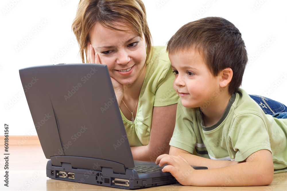 Surfing the web - woman and little boy laying on the floor with a laptop - isolated Surfing the web - woman and little boy laying on the floor with a laptop - isolated