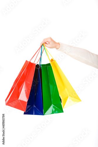 Woman hand holds coloured shopping bags. Isolated on white.
