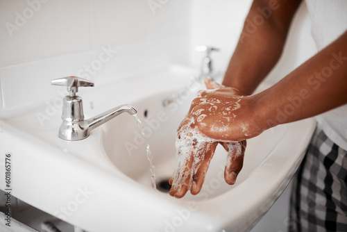Clean, hygiene and person washing hands in the bathroom with soap for wellness, health and bacteria prevention. Protection, home and man cleaning hand with water in his apartment as morning routine