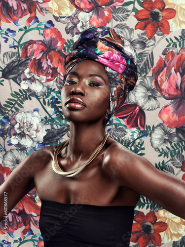 Black woman in portrait in turban, fashion on flower background and beauty, makeup and floral aesthetic. Natural cosmetics, female model in traditional African head wrap with creativity and style