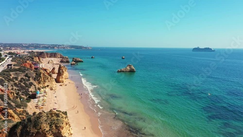 Portuguese southern beaches in aerial video city Portimao beach tres castelos. tourist cruise ship at sea in the background. photo