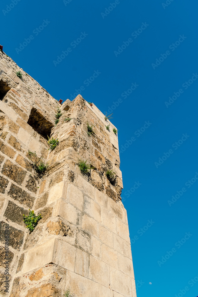 A fragment of the fortress wall in Antalya. Part of the fortress wall against the blue sky in the Turkish city of Antalya.