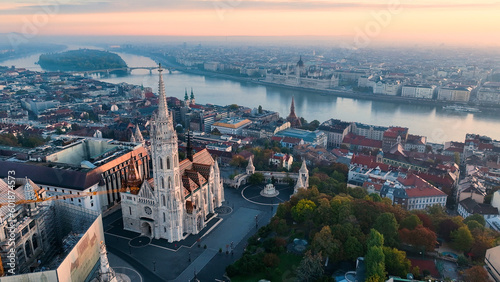 Budapest, Hungary, flying over the famous Fishermans Bastion and Matthias church towards the River Danube with Parliament of Hungary at background