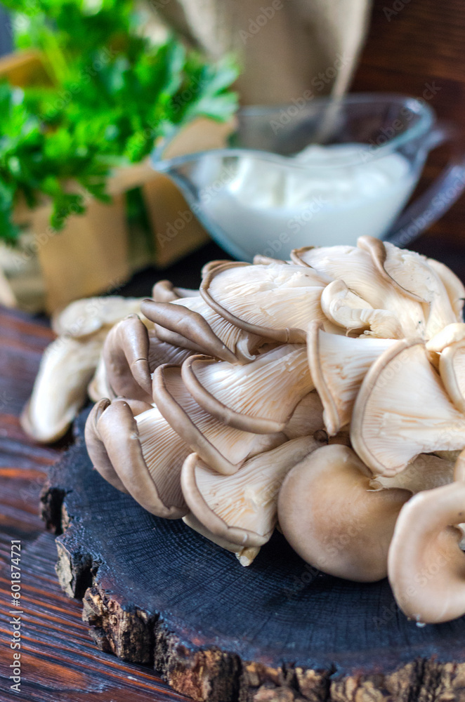 Fresh oyster mushrooms on a wooden board on the table Fresh oyster mushrooms on a wooden board on the table