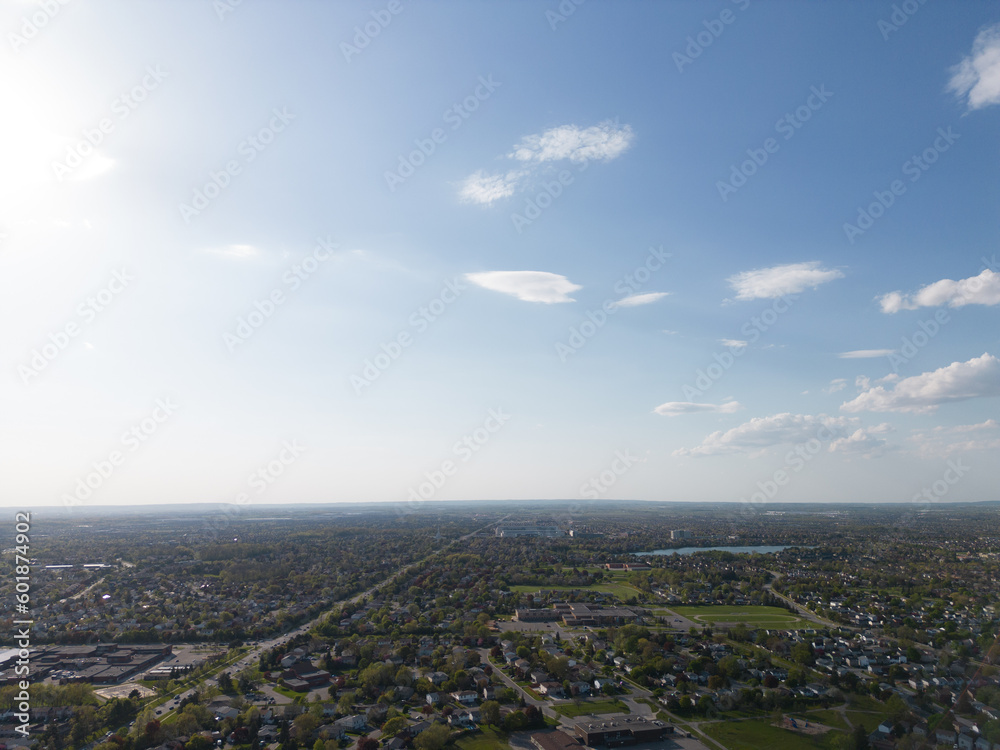 Drone view, sun-drenched Brampton real estate, lush green yards, picturesque houses off Bramalea-Mayfield. Summer in Ontario at its best
