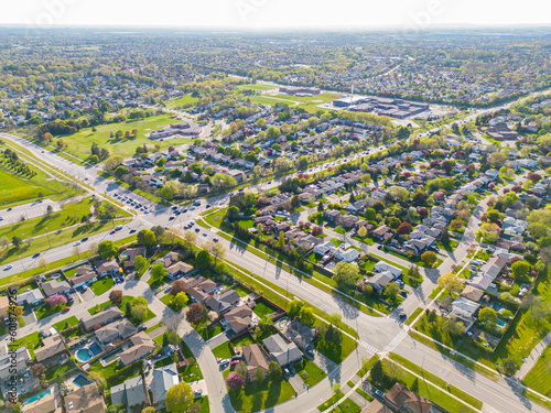 Drone view, sun-drenched Brampton real estate, lush green yards, picturesque houses off Bramalea-Mayfield. Summer in Ontario at its best