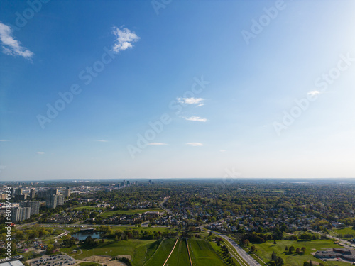 Drone view, sun-drenched Brampton real estate, lush green yards, picturesque houses off Bramalea-Mayfield. Summer in Ontario at its best
