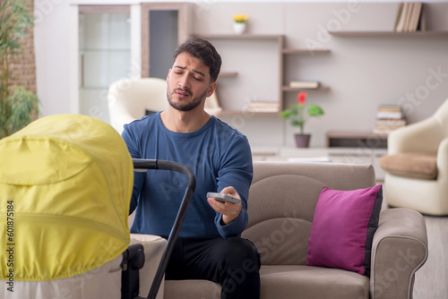 Young man looking after newborn at home