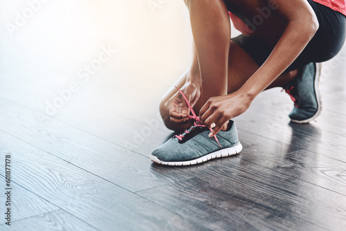 Sneakers, fitness and person tie laces to start exercise, workout or wellness sport in a gym for health performance. Shoes, space and hands of a healthy woman or runner ready for training or sports