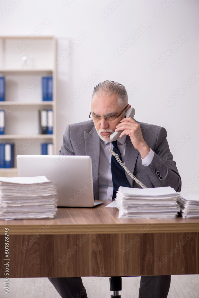Old male employee and too much work at workplace Old male employee and too much work at workplace
