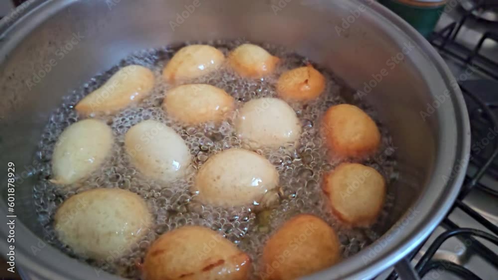 Frying raincake, in slow motion, typical food in Brazil, fried dough in oil, 4k, selective focus. Frying raincake, in slow motion, typical food in Brazil, fried dough in oil, 4k, selective focus.