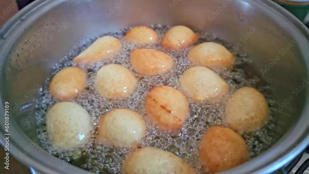 Frying raincake, in slow motion, typical food in Brazil, fried dough in oil, 4k, selective focus. Frying raincake, in slow motion, typical food in Brazil, fried dough in oil, 4k, selective focus.