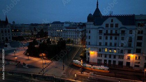 Aerial view of Typical Budapest Tram passing through city neighbourhood during blue hour, Aerial tracking follow shot wide angle, Hungary