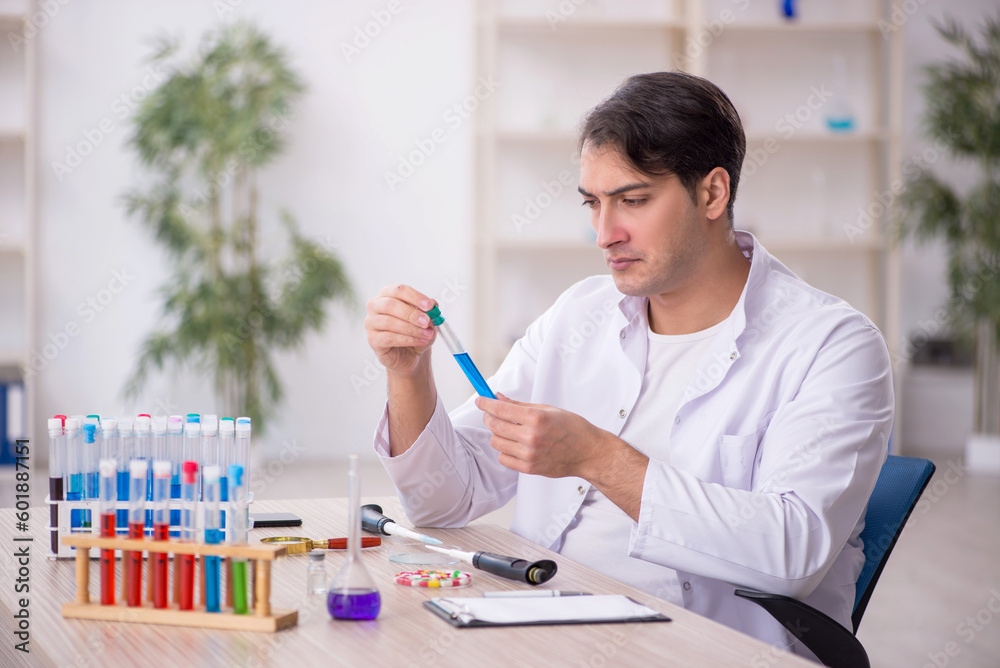 Young male chemist working at the lab