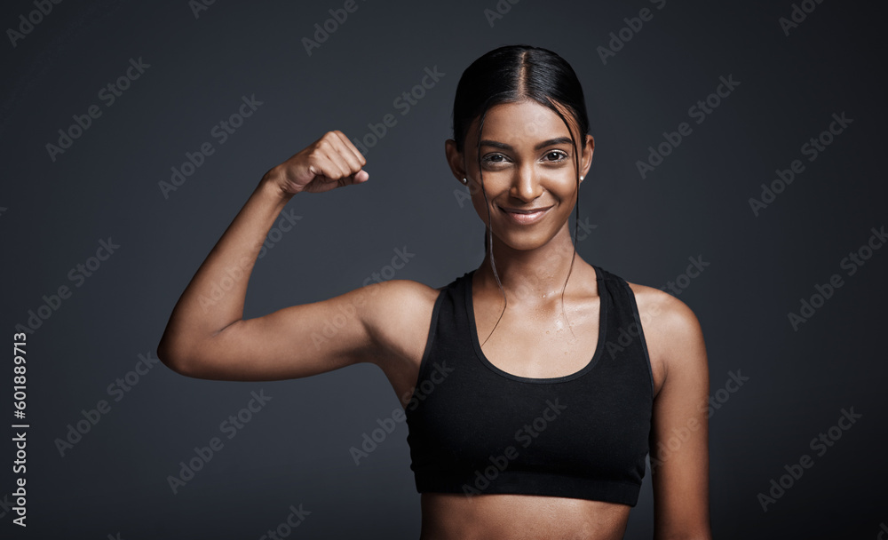 Portrait, smile and woman flexing muscle in studio isolated on black background. Strong, happy and Indian female athlete with bicep, arm strength and bodybuilder workout, fitness or sports exercise. Portrait, smile and woman flexing muscle in studio isolated on black background. Strong, happy and Indian female athlete with bicep, arm strength and bodybuilder workout, fitness or sports exercise.