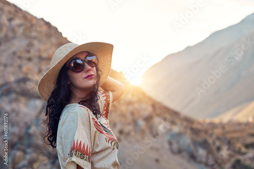 portrait young latin woman with hat and glasses with hills in the background in the elqui valley