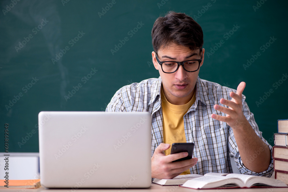 Young male student preparing for exams in the classroom Young male student preparing for exams in the classroom