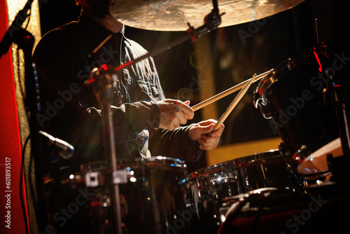 Close-up of drummer drumsticks with a drum set.