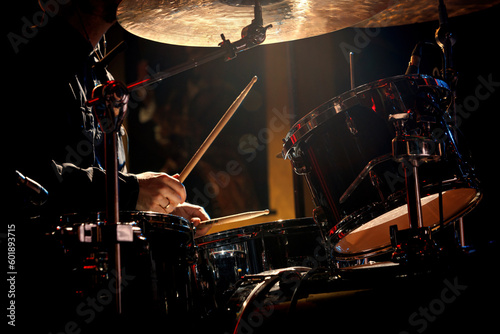 Photography Drummer playing with drumsticks on a rock drum set.