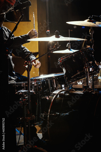 Percussionist performing on rock drum set with drumsticks. © 9parusnikov