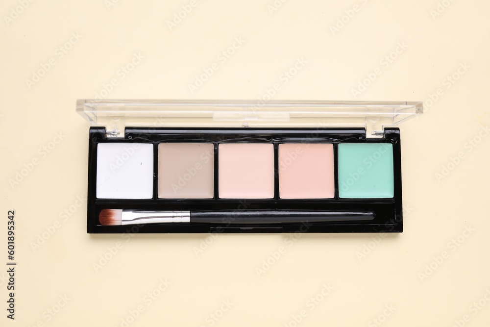 Colorful contouring palette with brush on beige background, top view. Professional cosmetic product Colorful contouring palette with brush on beige background, top view. Professional cosmetic product