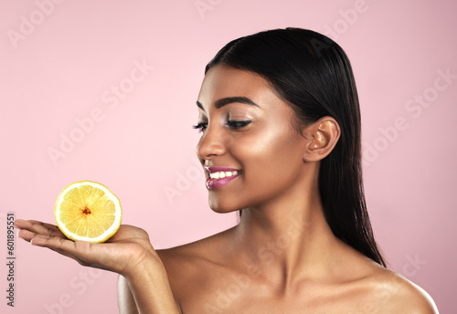 Skincare, face and smile of woman with an orange in studio isolated on pink background. Fruit, natural cosmetics and Indian female model holding food for healthy diet, nutrition or vitamin c to detox