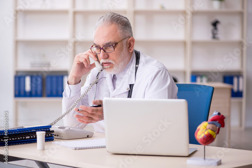 Old male doctor in telemedicine concept