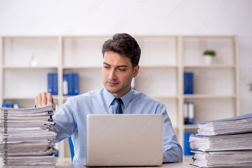 Young male employee and too much work in the office