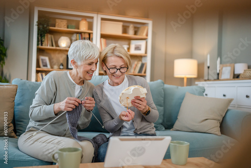 two women senior mature knitting and embroidery during leisure time