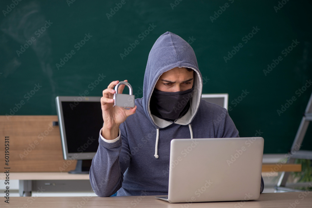 Young male hacker sitting in the classroom Young male hacker sitting in the classroom