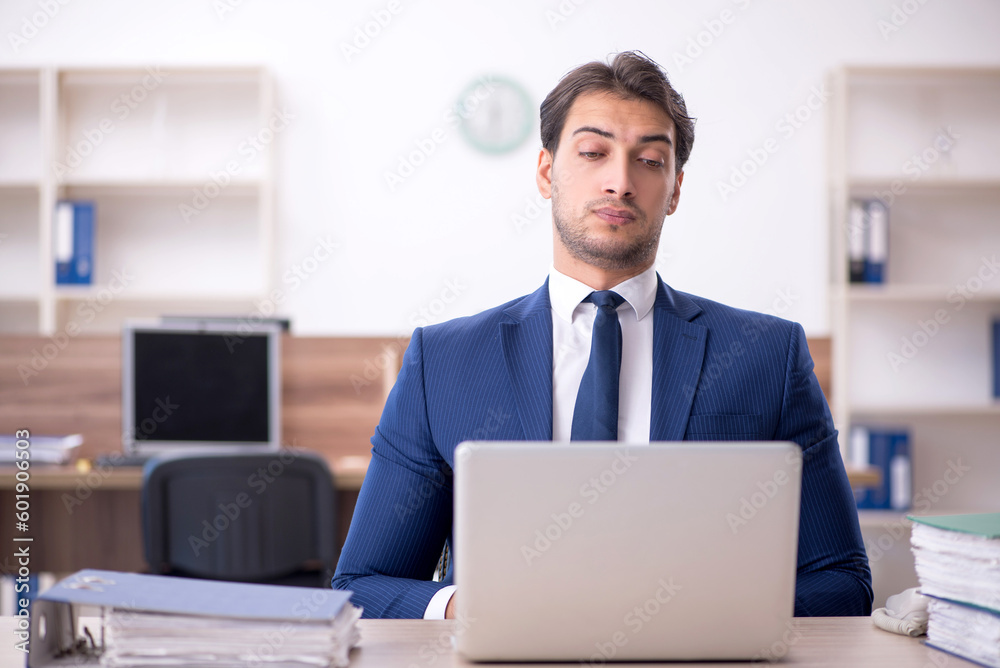 Young male employee and too much work in the office Young male employee and too much work in the office