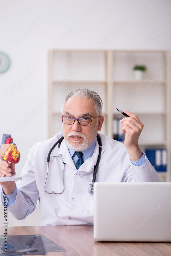 Old male doctor cardiologist working in the clinic Old male doctor cardiologist working in the clinic