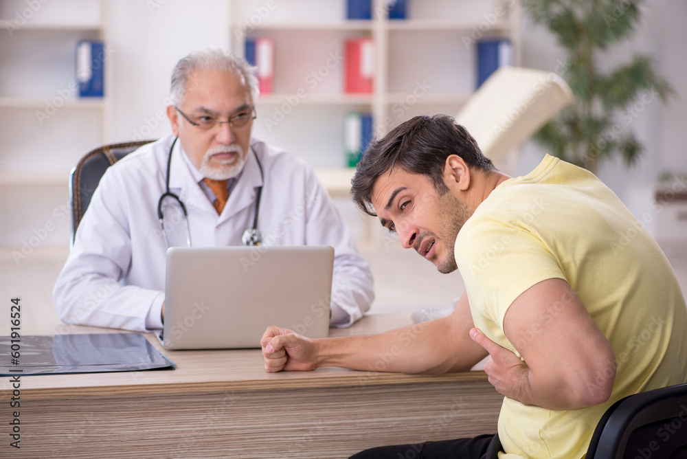 Obraz premium Young male patient visiting old male doctor