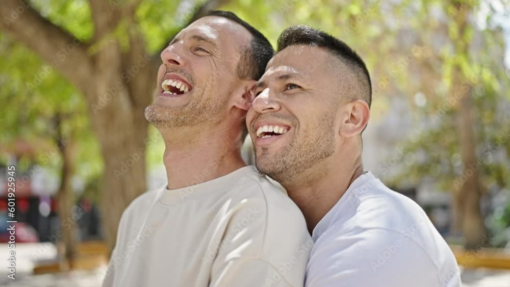 Two men couple smiling confident standing together at park Two men couple smiling confident standing together at park