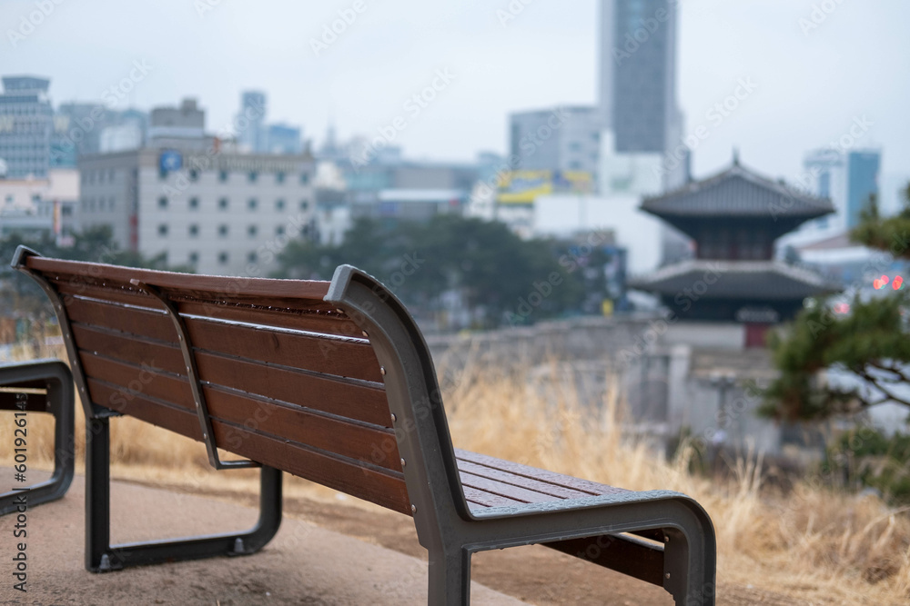 A bench with view of the city from Heunginjimun park in Dongdaemun area of Seoul, South Korea