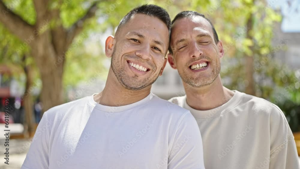 Two men couple smiling confident standing together at park Two men couple smiling confident standing together at park
