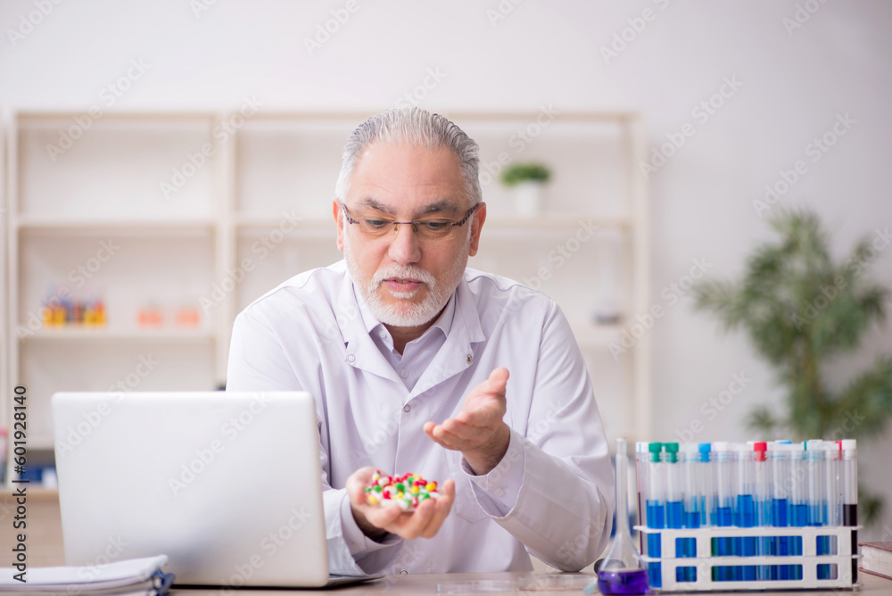Old male chemist working at the lab Old male chemist working at the lab