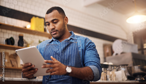 Focus, tablet and manager with man in cafe for online, entrepreneurship and startup. Waiter, technology and food industry with small business owner in restaurant for barista, african and coffee shop