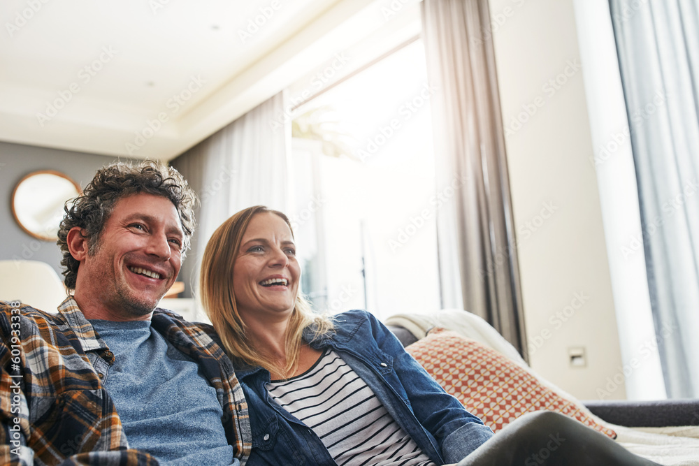 Fototapeta premium Laughing couple, relax and watching tv in home for funny movie, comedy show and media connection in lounge. Mature man, happy woman and smile for television, video subscription and streaming platform