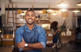 Coffee shop, crossed arms and portrait of black man in restaurant for service, working and happy in cafe. Small business owner, bistro startup and confident male waiter in cafeteria ready to serve