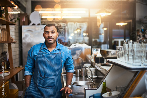 Coffee shop, barista and portrait of man in restaurant for service, working and standing by cafe counter. Small business owner, bistro startup and serious male waiter in cafeteria ready to serve