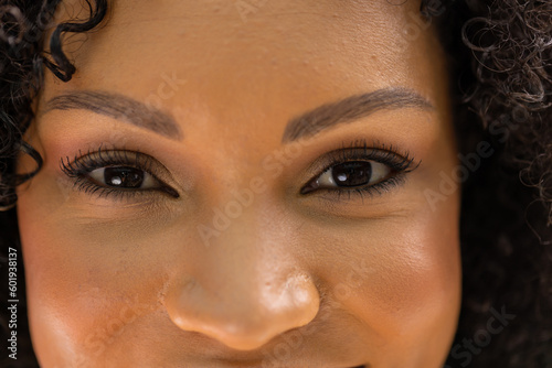 Portrait close up of the eyes pf smiling african american woman in garden, with copy space