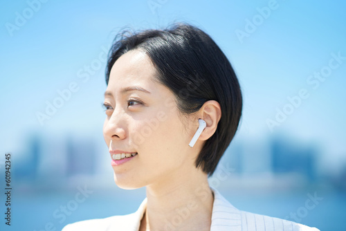 ワイヤレスイヤホンを装着した女性 Free Download ワイヤレスイヤホンを装着した女性 - GFXLoad