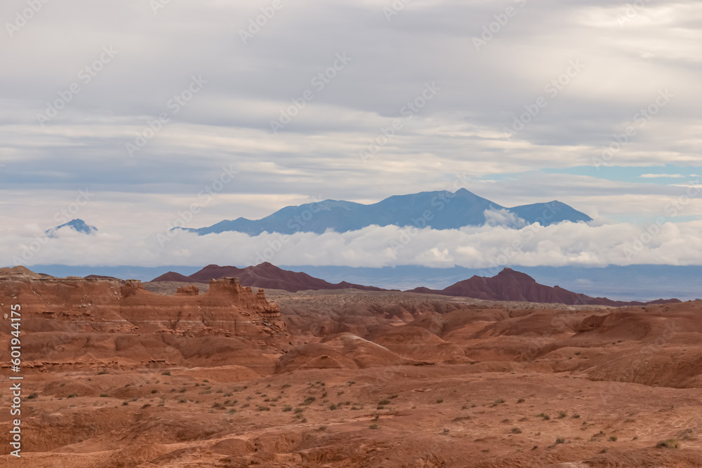 Panoramic view of the cloud covered Henry mountain range seen from the Goblin Valley State Park near Hanksville, Utah, USA. Unique Hoodoo Estrada sandstone rock formations in San Rafael Swell
