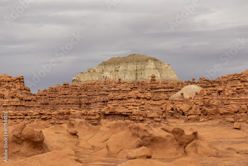 Scenic view on White Butte Looming over Red Rocks in Goblin Valley State Park, Utah, USA. Unique eroded Hoodoo Estrada sandstone rock formations. Mushroom-shaped rock pinnacles in San Rafael Swell