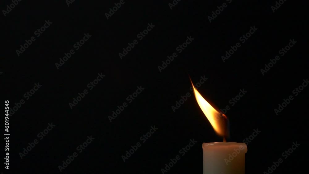 Close-up single candle burning on dark black background, candle fire flame light Close-up single candle burning on dark black background, candle fire flame light