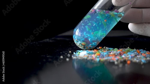 Close-up shot of a test tube full of micro plastics collected from the beach. Concept of water pollution and global warming. 